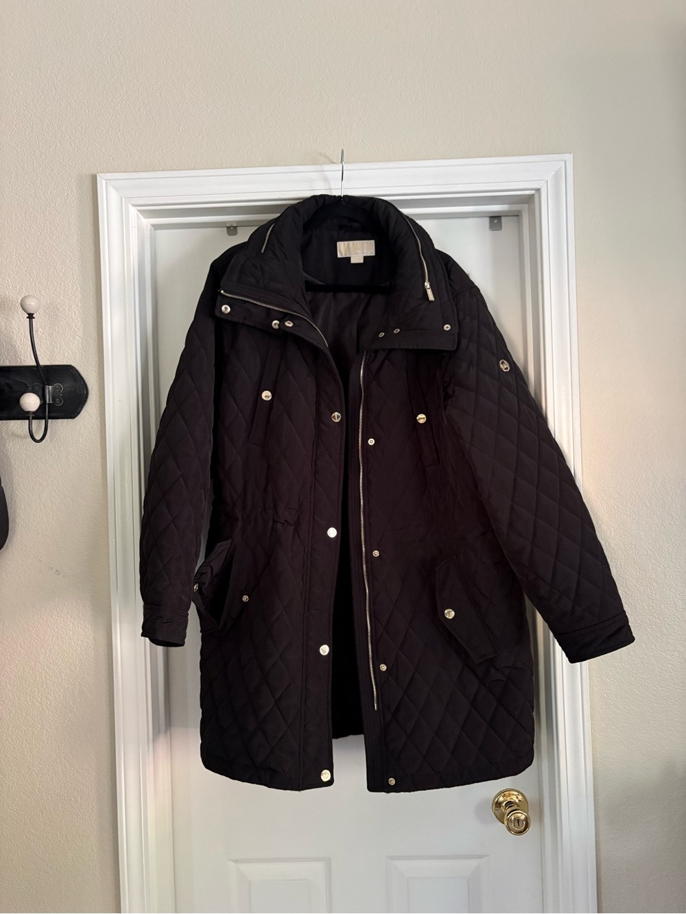 Michael Kors Black Quilted Long Puffer Jacket includes a hood in zippered collar